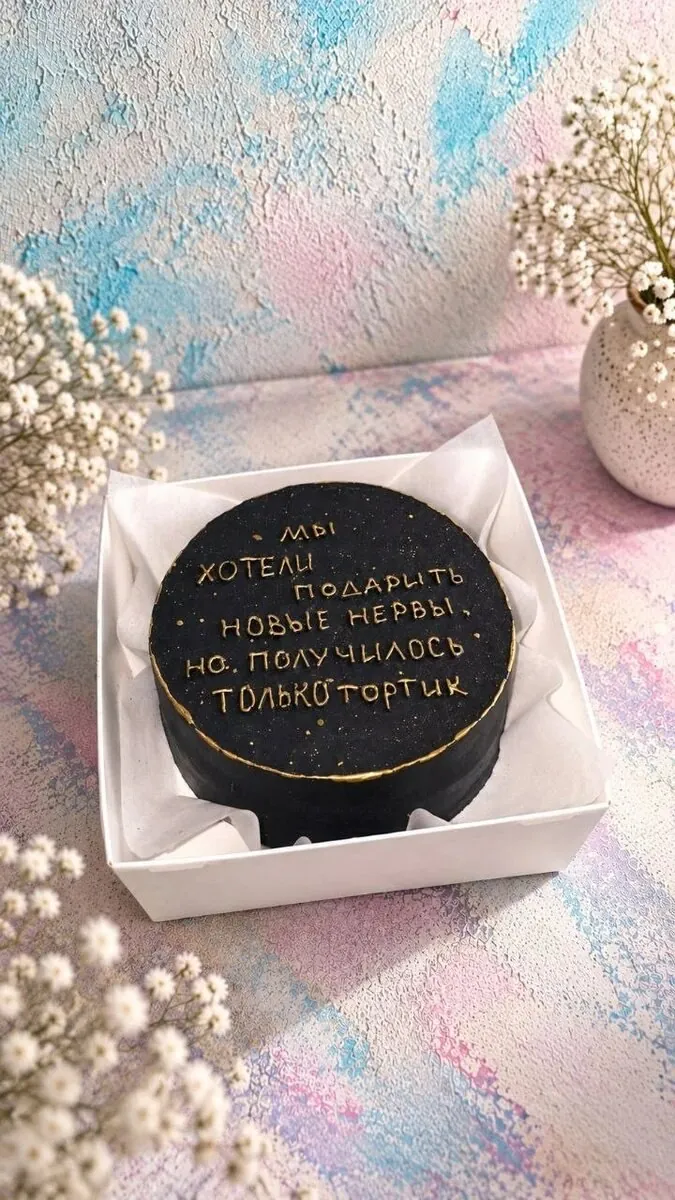 Чёрный бенто-торт с золотой надписью «Мы хотели подарить новые нервы, но получился только тортик»